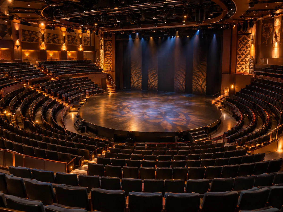 Curved rows of seats wrapping around a round thrust stage in an intimate theater